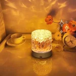 Glowing crystal mood light projecting warm amber ocean wave effects on a bedside table.