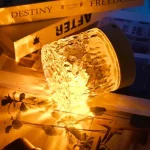 Close-up of the dynamic rotating crystal surface reflecting golden light sparkles.