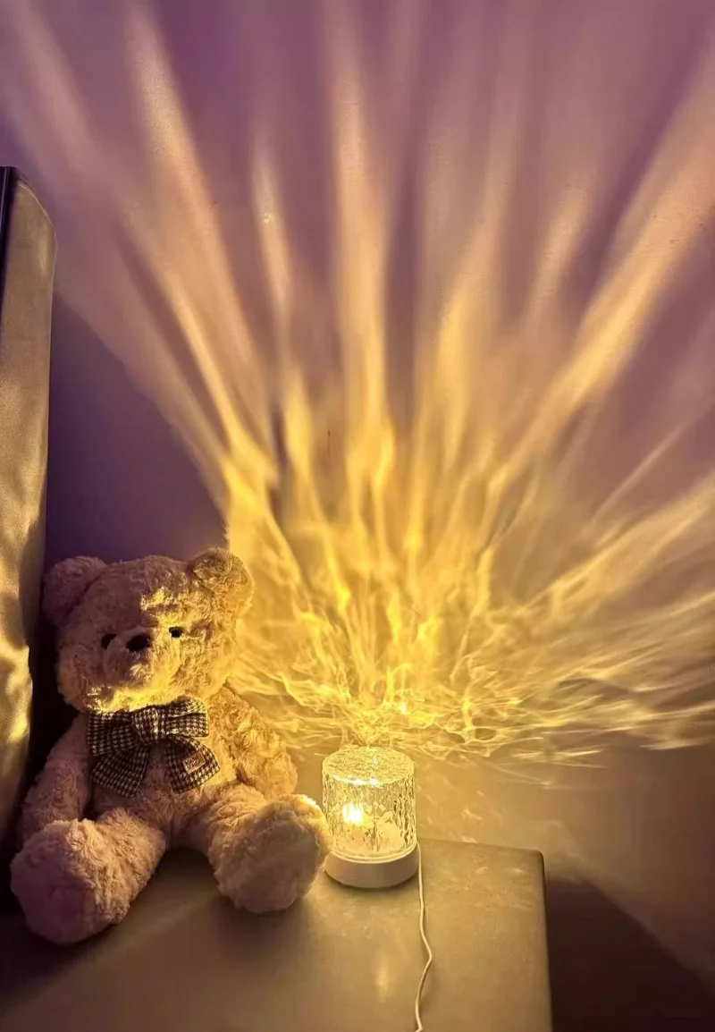 Soft ambient lighting from a ripple lamp creating a dreamy flame-like effect behind a teddy bear.