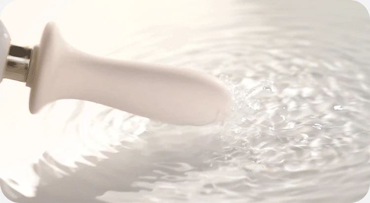 Waterproof silicone massage head vibrating in water ripples.