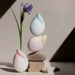 Artistic lifestyle composition featuring the HH Budding Moon floral-inspired clitoral vibrators in soft pastel gradients of pink, blue, and yellow.