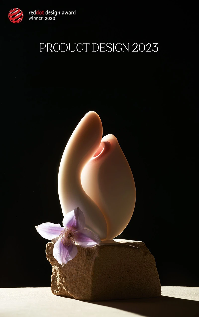 High-aesthetic shot of the Budding Moon pleasure device resting on a stone, featuring its 2023 Red Dot Design Award-winning floral silhouette and artistic petal-like contours.