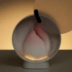 The HH Budding Moon stored in its elegant, vanity-mirror inspired charging case which features a soft-glow built-in night light.