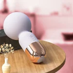 HH Candy Massager Mini resting on a wooden bedside table next to a vase, emphasizing its aesthetic design and discreet presence as a luxury wellness tool.