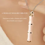 Close-up of a woman wearing a discreet necklace vibrator with a gold-accented jewelry ring.