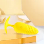Detailed view of the flexible T-bar base and integrated power button on the vibrant yellow textured pleasure device.