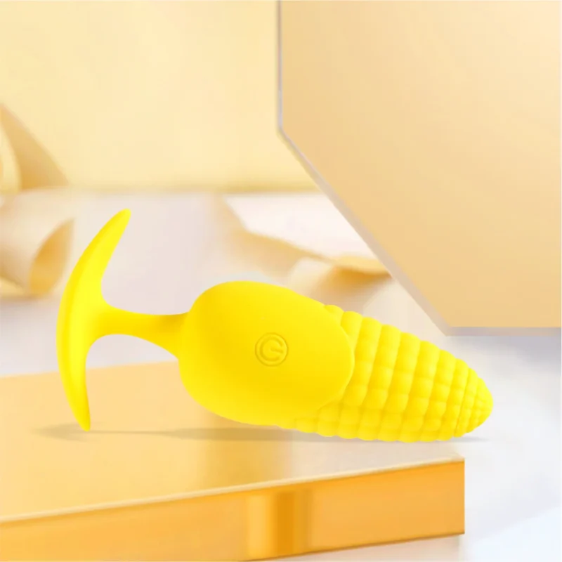 Detailed view of the flexible T-bar base and integrated power button on the vibrant yellow textured pleasure device.