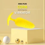 Professional studio shot of a textured corn-design prostate massager on a minimalist yellow pedestal.