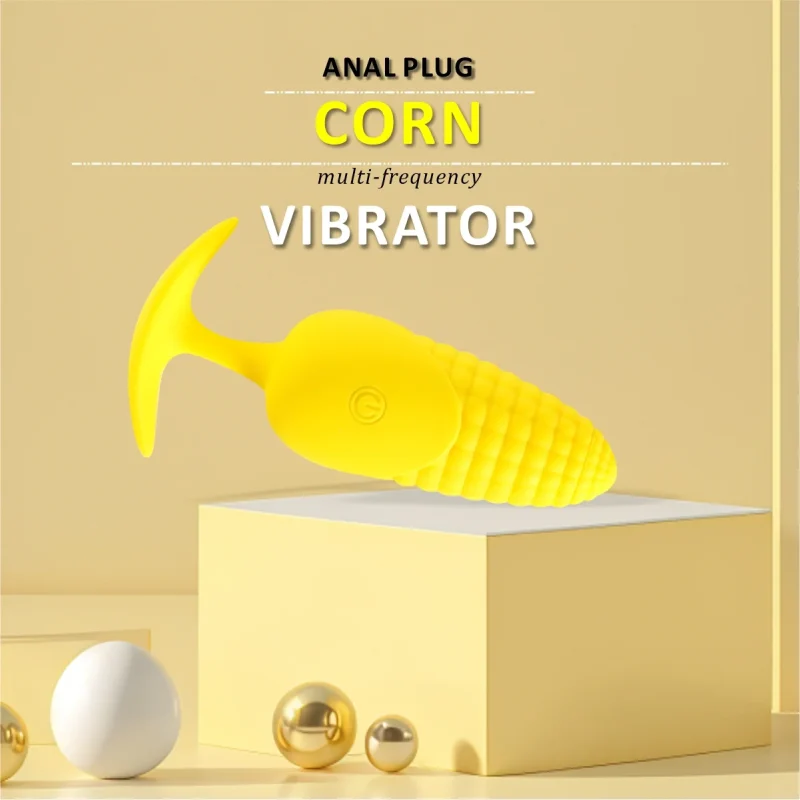 Professional studio shot of a textured corn-design prostate massager on a minimalist yellow pedestal.