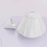 Top-down view of the ergonomic suction head and cap on a sleek, moisture-resistant pearlescent surface.