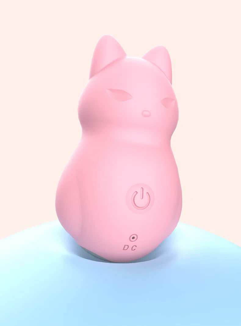 Side-angle shot of the fox-shaped silicone vibrator resting on a soft blue surface, showcasing its smooth, rounded contours.