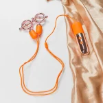 Intimate pleasure device featuring dual vibration points and a sleek rose gold hand-held transmitter on silk fabric.