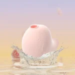 A soft pink Dudu Bird clitoral stimulator shown emerging from a refreshing water splash, highlighting its fully waterproof design and aquatic play capabilities.