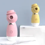 Two HH Gentleman clitoral suction toys in pink and yellow displayed on a modern marble vanity, showcasing the discreet and aesthetic design of these adult pleasure devices.