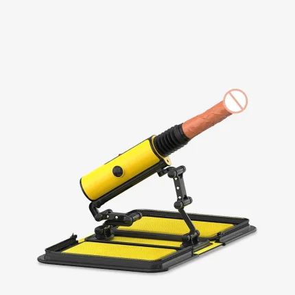 Fully assembled yellow automatic thrusting device on a stable folding base featuring a realistic silicone attachment and adjustable support arm.