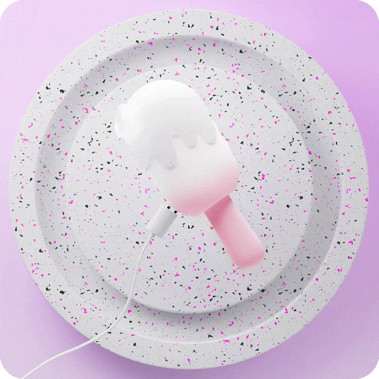 The HH Ice Pop adult product shown with its magnetic USB charging cable on a modern terrazzo-style display stand for a luxury lifestyle feel.