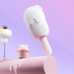 Lifestyle shot of the discreet HH Ice Pop massager standing upright next to a cupcake, emphasizing its playful and "hide-in-plain-sight" aesthetic.
