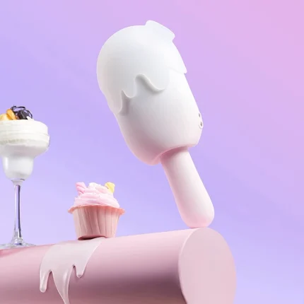Lifestyle shot of the discreet HH Ice Pop massager standing upright next to a cupcake, emphasizing its playful and "hide-in-plain-sight" aesthetic.