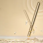 High-end golden Joy Rod pleasure wand hovering over water with ripple effects symbolizing powerful vibration technology.