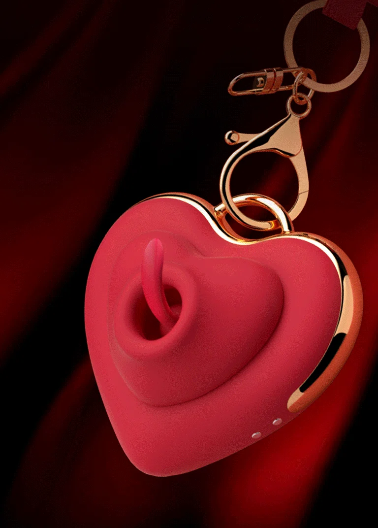 A heart-shaped licking vibrator in vibrant red featuring a gold-toned keychain attachment for discreet, on-the-go portability.