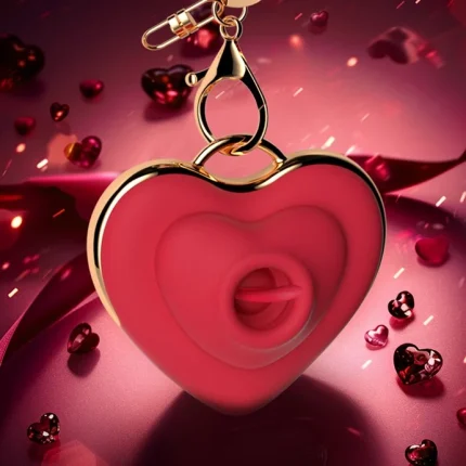 Luxurious product photography of the HH Kiss heart-shaped massager suspended by its gold hardware against a romantic red bokeh background.