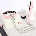 Close-up of the pink vegan leather kitty collar with a cat-head shaped D-ring and a detachable stainless steel leash for sensory play.