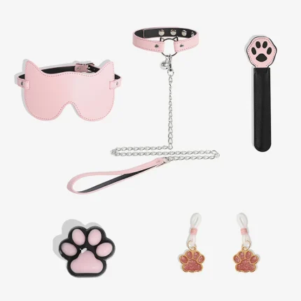 Complete 5-piece Kitty Love intimacy set including a pink cat-ear blindfold, bell collar with leash, paw paddle, sensory candle, and glittering nipple clamps.