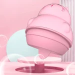 An artistic rendering of the pink cat-shaped tongue vibrator hovering over a pedestal, highlighting its playful and discreet "Doudou Egg" design.