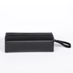 Side profile of a sleek black leather-style storage pouch with a sturdy zipper and a convenient wrist strap for portable discreet transport.