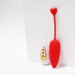 Minimalist lifestyle shot of the crimson red carrot stimulator with its elegant gold and white wireless remote control.