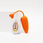 Flexible silicone heart-tail retrieval pull on the orange carrot vibrator, demonstrating the soft-touch material and ergonomic curve.