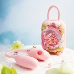 Lifestyle view of the ergonomic pink pleasure tool and its hardshell charging case resting on a soft lace surface with floral decor.