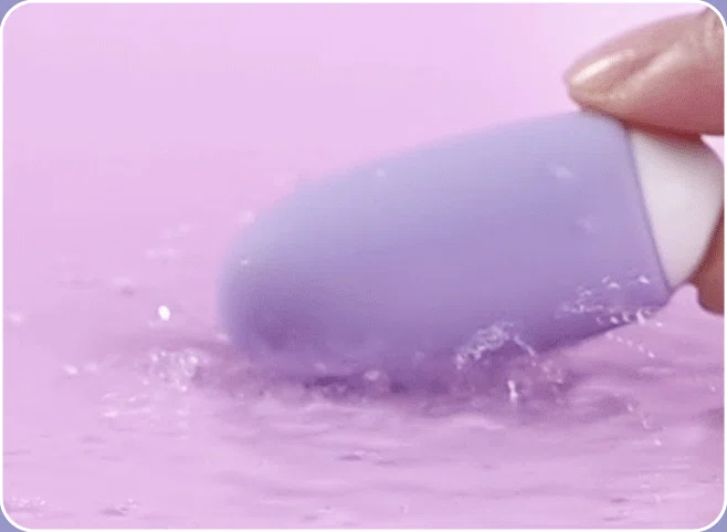 Close-up action shot demonstrating the fully waterproof medical-grade silicone exterior of the vibrating egg during water-play or easy cleaning.