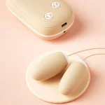 High-angle shot of the Magic Box double vibrator and magnetic charging case in a soft peach aesthetic.