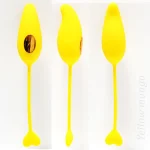 Three-angle studio shot of the yellow mango-shaped jumping egg featuring its smooth medical-grade silicone texture and heart-shaped pull tab.