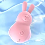 A pink waterproof clitoral vibrator submerged in water, demonstrating its IPX7 rating for aquatic play and easy cleaning.