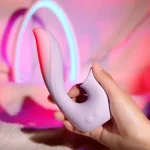 Close-up of a hand holding the flexible lilac-colored silicone vibrator, showcasing the soft-touch texture and dual-button control interface.