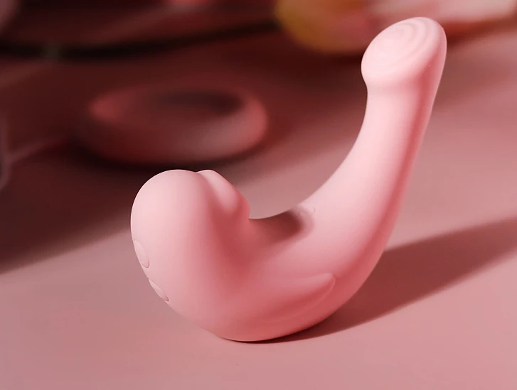 Close-up of the HH Pebble pleasure device in soft pink, highlighting the smooth silicone finish and the ergonomic, whale-inspired aesthetic.