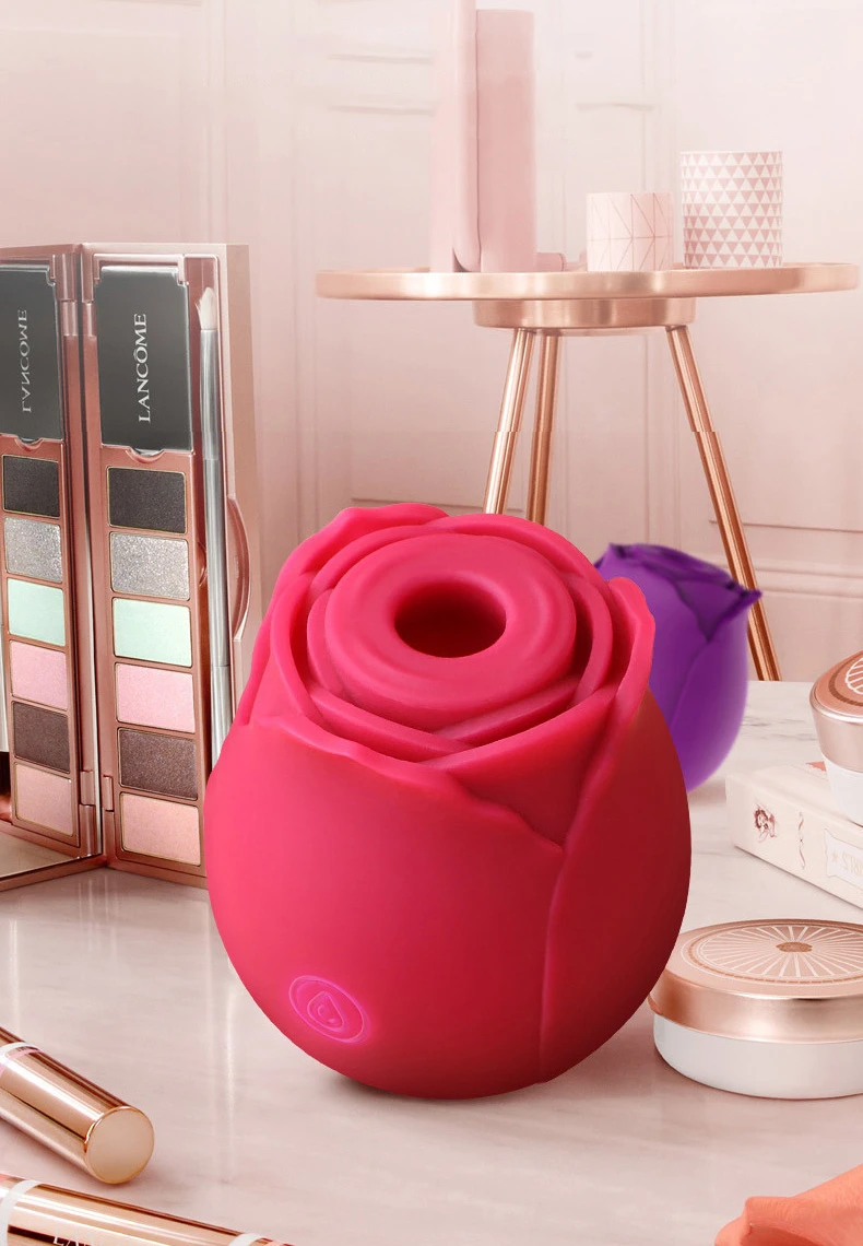 Luxury rose vibrator in a vibrant magenta hue styled on a vanity with high-end cosmetics for elegant bedroom decor.