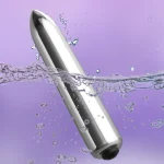 Action shot of a silver waterproof vibrator floating in bubbling water, illustrating its durable and fully submersible construction.