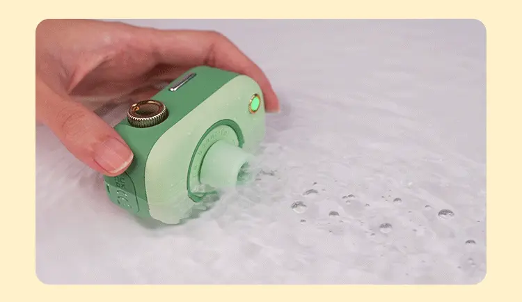 Waterproof adult device being cleaned under water, demonstrating the IPX7 rating and easy-to-sanitize surface of the silicone massager.