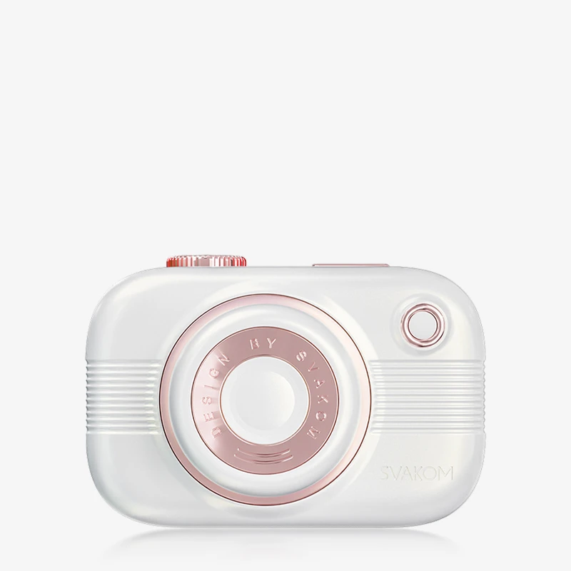 hh-snapshot-pleasure-24b Perspective view of a white travel-friendly air-pulse stimulator, showcasing the ergonomic "lens" nozzle and the textured power buttons located on the top of the device.