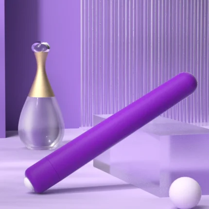 Lifestyle shot of the elegant purple intimacy device next to a glass perfume bottle, emphasizing its stylish aesthetic and travel-friendly portability.