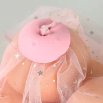 The HH pink vibrating breast clamp resting on delicate lace fabric for a feminine product presentation.