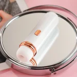 Travel-friendly mini vibrator reflected in a vanity mirror, highlighting its discreet and elegant lipstick-style design for modern lifestyle integration.