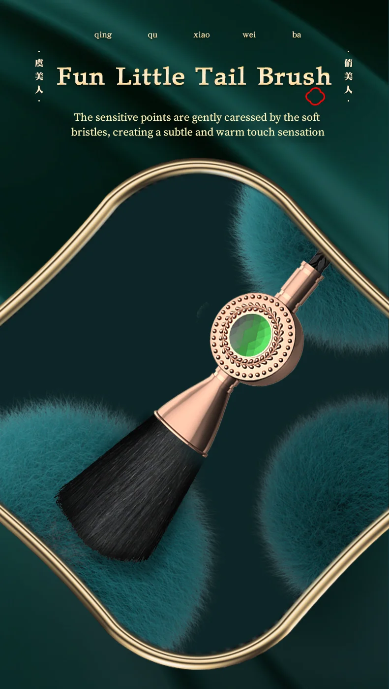 Close-up of the "Fun Little Tail Brush" accessory featuring soft black bristles and a decorative green gemstone inlay for sensory play.