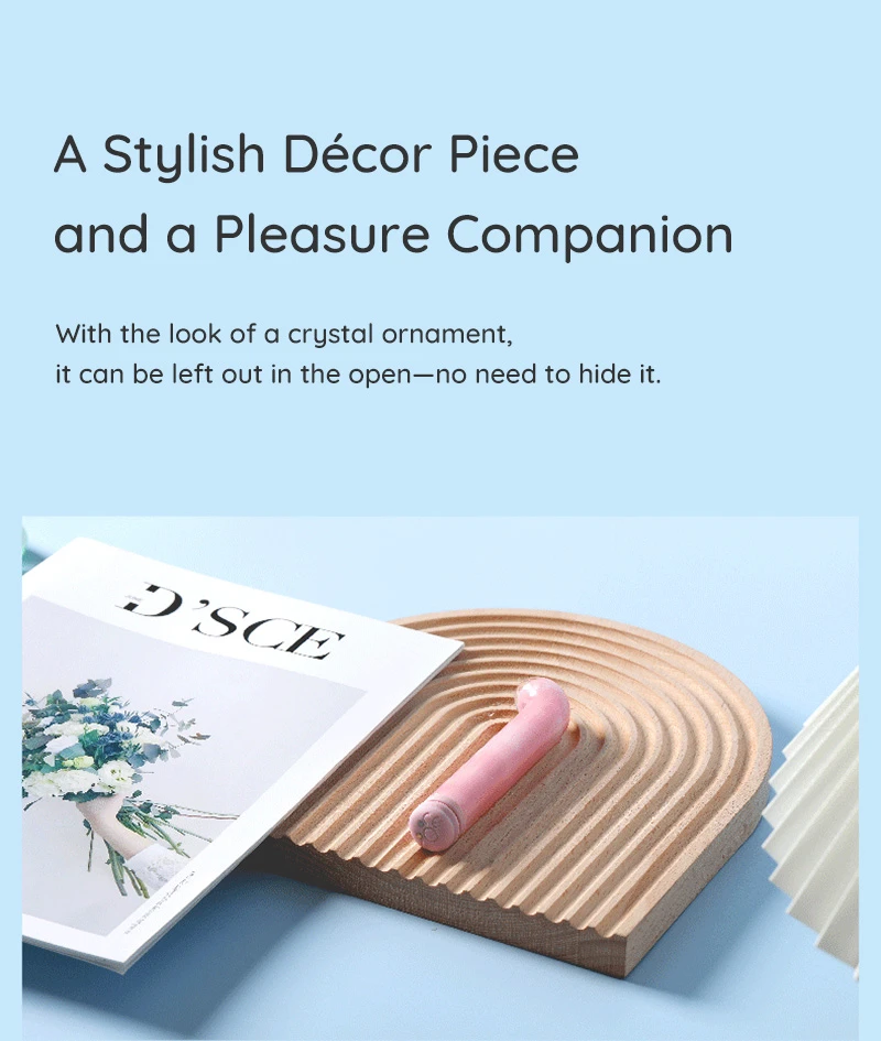 Pink curved vibrator displayed on decorative tray beside magazine