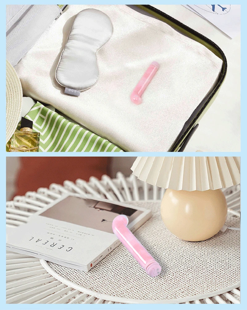 Compact pink curved glass vibrator displayed on towel and side table