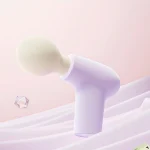 lavender mini handheld percussion massage gun product shot on pastel background