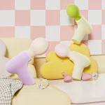 pastel color mini percussion massager collection styled in cozy room setting with decorative display